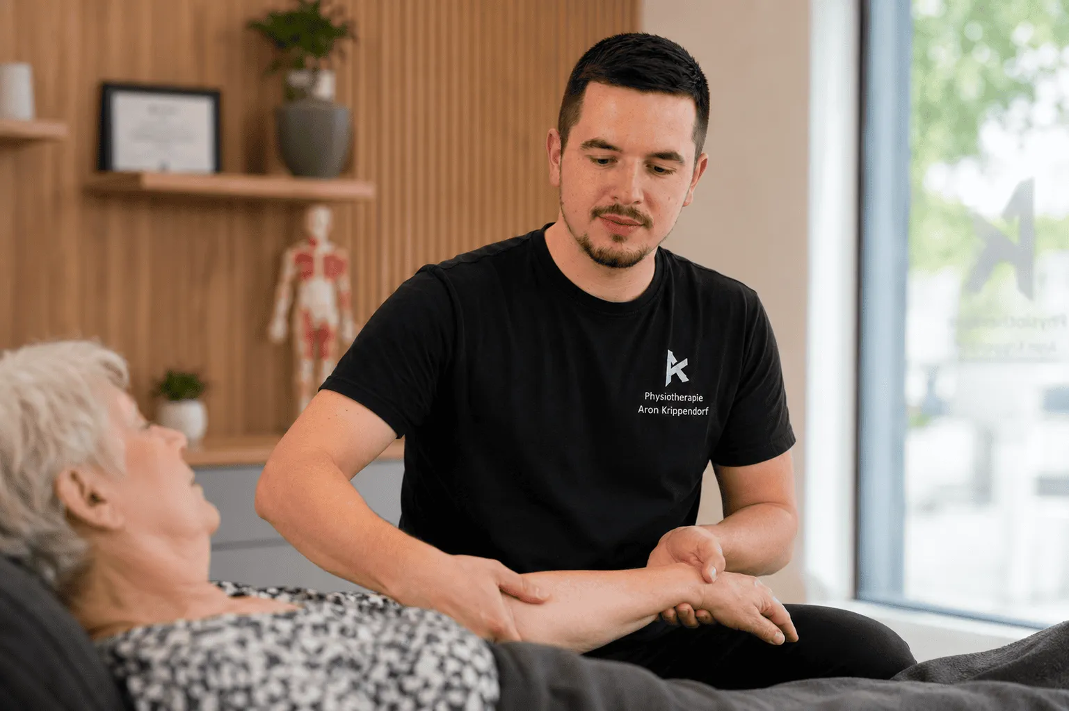 Therapeut der Praxis Aron Krippendorf bei der Behandlung einer Patientin